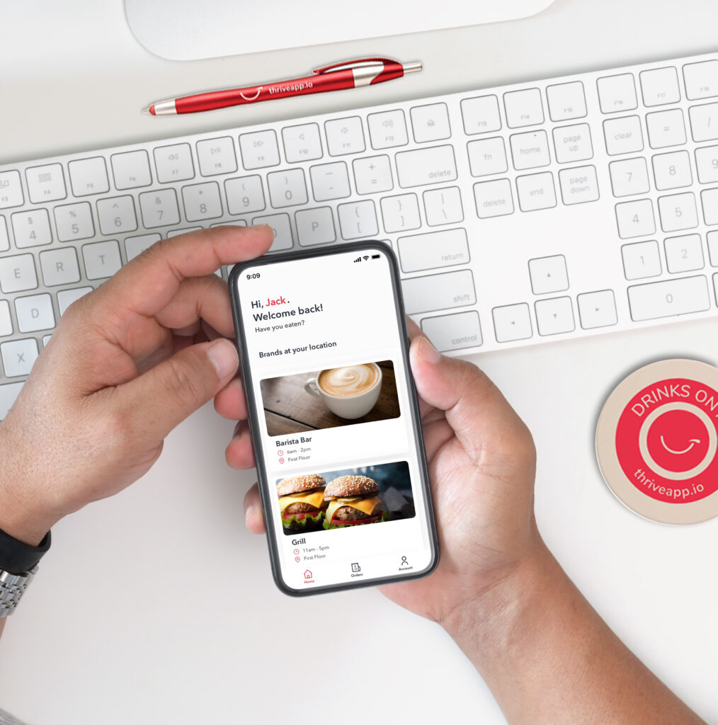 A person at their work desk using the Thrive app on their mobile phone